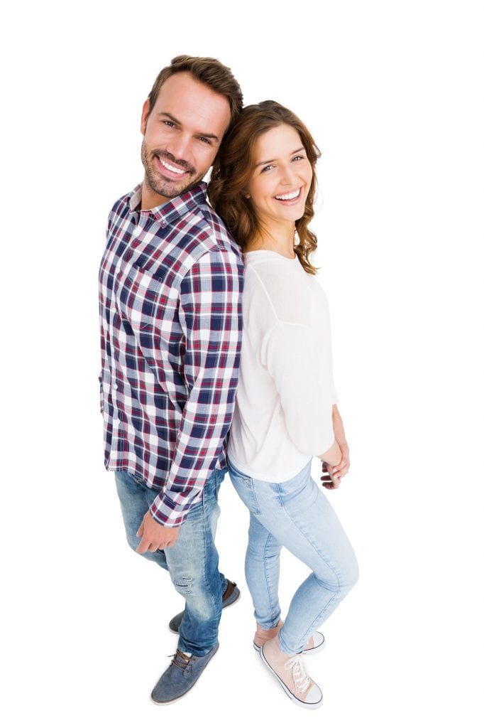Portrait Of Happy Young Couple Standing Back To Back On White Back Ground